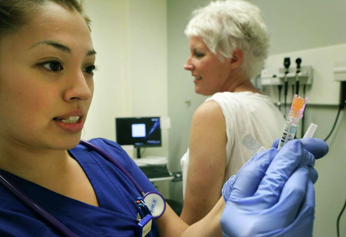 A medical assistant at Primary Care Clinic of UT Medicine San Antonio prepares to administer a flu shot in 2015. The Affordable Care Act has spurred consolidation in the medical field, but that hasn’t translated into lower costs for patients.