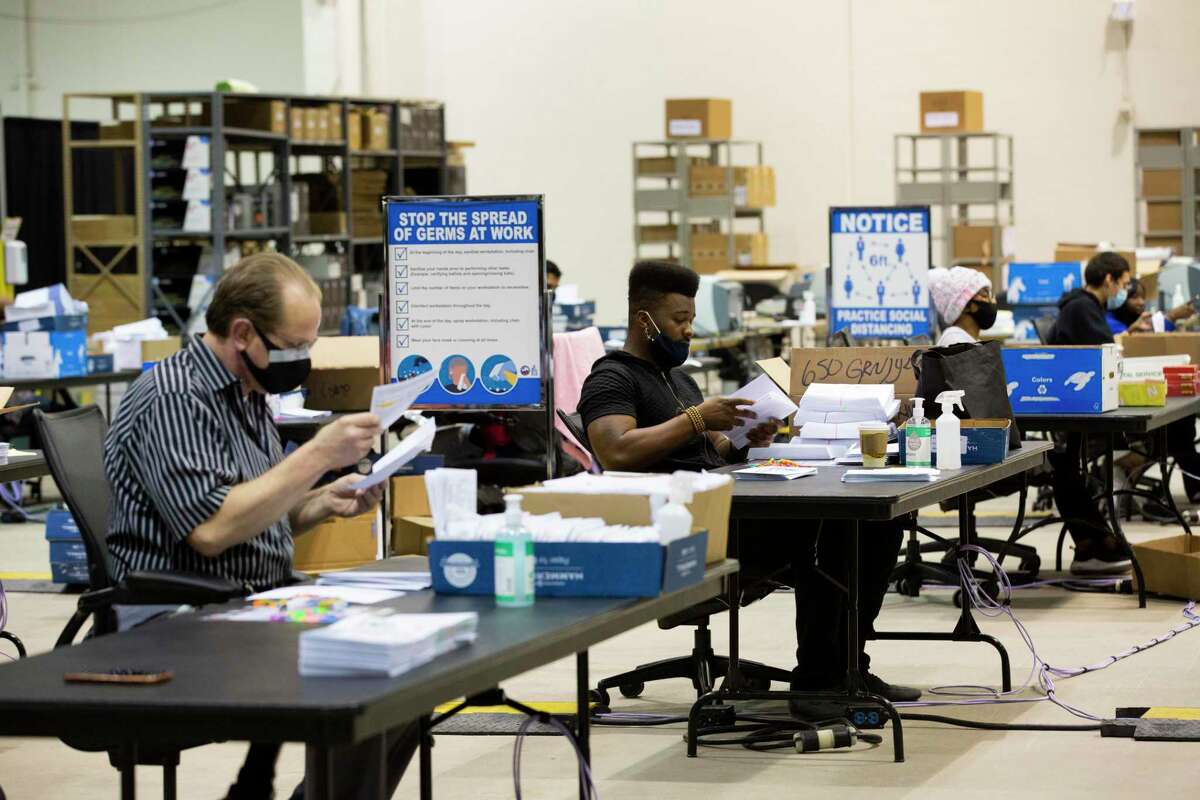 Harris County workers prepare early voting mail-in ballot envelopes to be sent to voters from the Harris County Clerk’s election headquarters at the NRG Arena on Friday, Sept. 25, 2020, in Houston.
