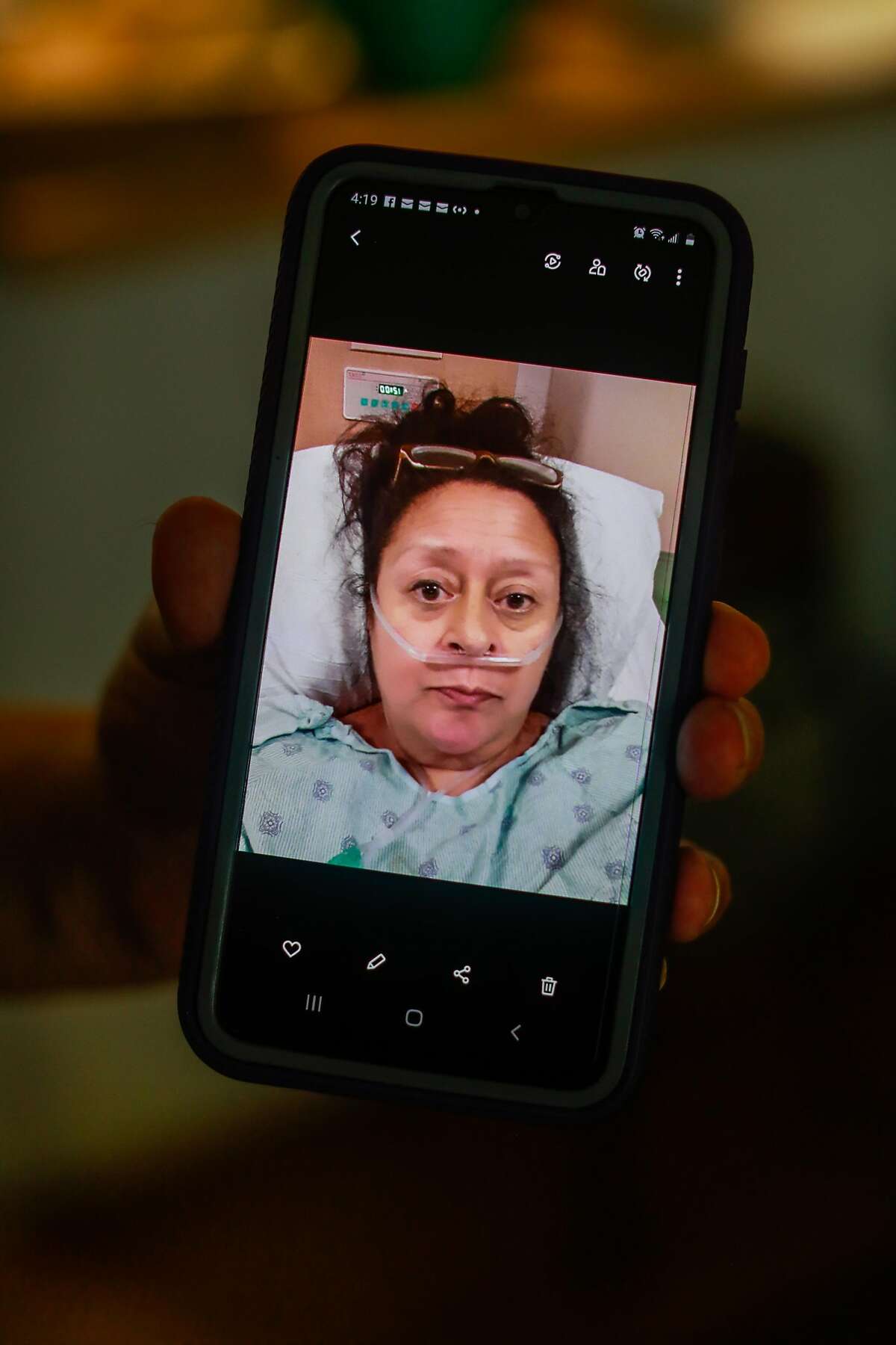 Charlotte Juarez shows a photo from her phone from when she was in the hospital on Thursday, Sept. 24, 2020 in Burlingame, California. Charlotte was in the hospital with the coronavirus in June and is still experiencing lingering effects including fatigue and heart palpitations.