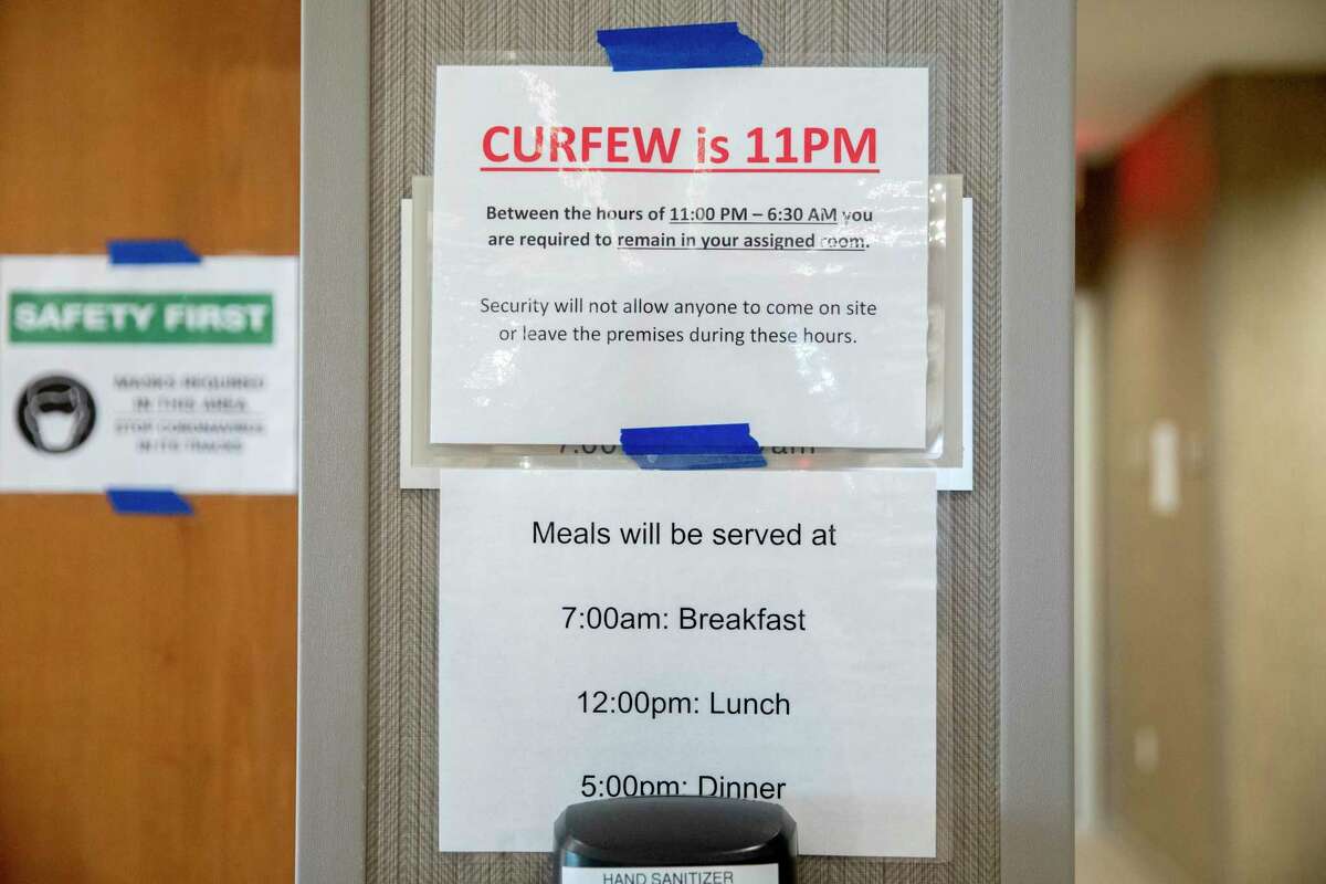 Signs remind visitors of meal times, curfew and mask requirements at an undisclosed hotel housing the homeless during the COVID-19 pandemic in the Bay Area, Calif. Thursday, August 6, 2020. The race is on to get in on the first round of applications for $100 million in Project Homekey funding to covert hotels in the Bay Area into permanent homeless housing such as this one. The first deadline is August 13, 2020.