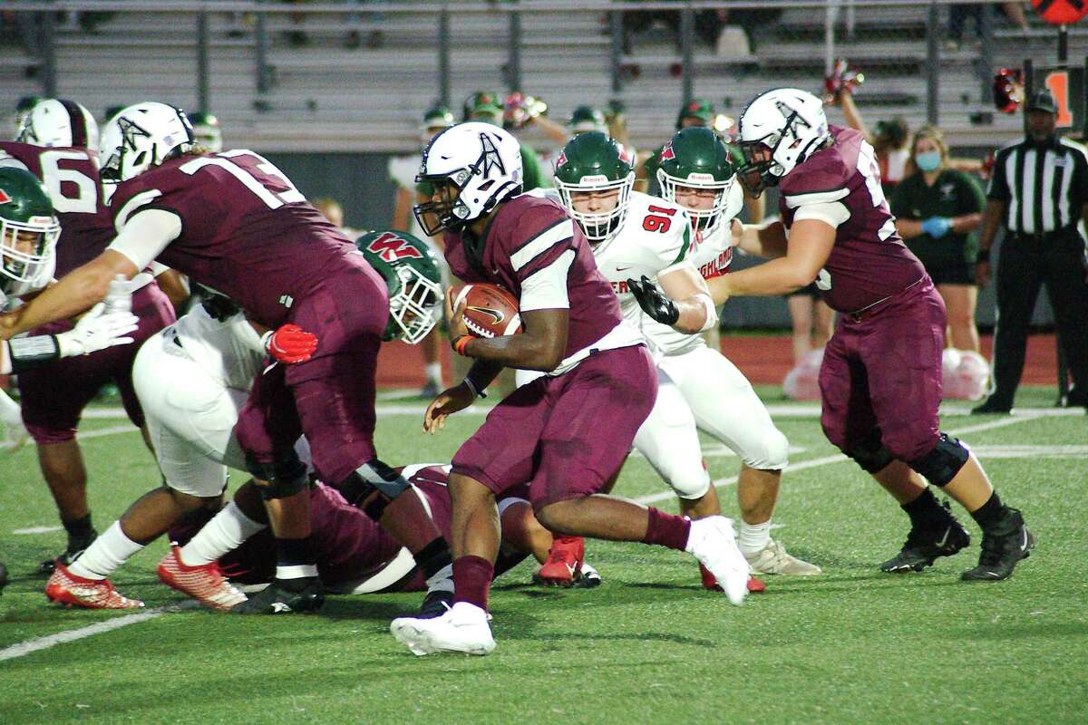 Pearland’s Darius Hale (4) looks for running room against The Woodlands Friday at The Rig.