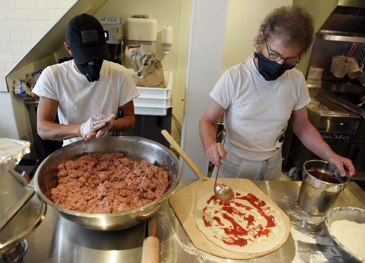 Oswaldo Ramirez, left, makes meatballs while co-owner Louis Termini makes a pizza at Ignazio's Pizza in Greenwich on Tuesday. Located at 30 Greenwich Ave., the Greenwich restaurant joins other Ignazio's locations in Brooklyn and Westport.