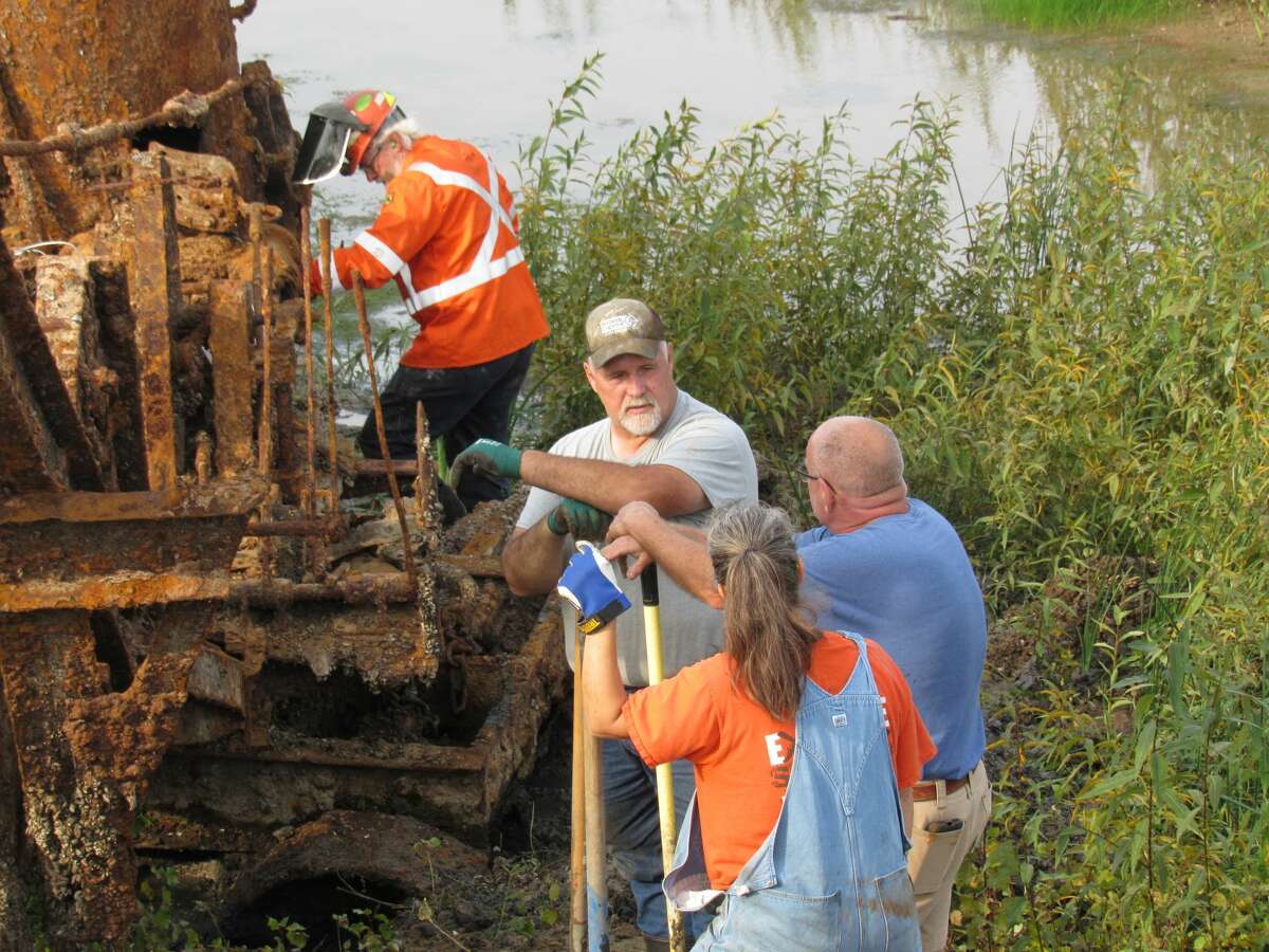 A group of volunteers led by Mike Oberloier excavate a 1901 Thew model steam-powered shovel, which was unearthed on the bottom of Wixom Lake after the failure of the Edenville Dam, on Sept. 26, 2020.  (Mitchell Kukulka/Mitchell.Kukulka@mdn.net)