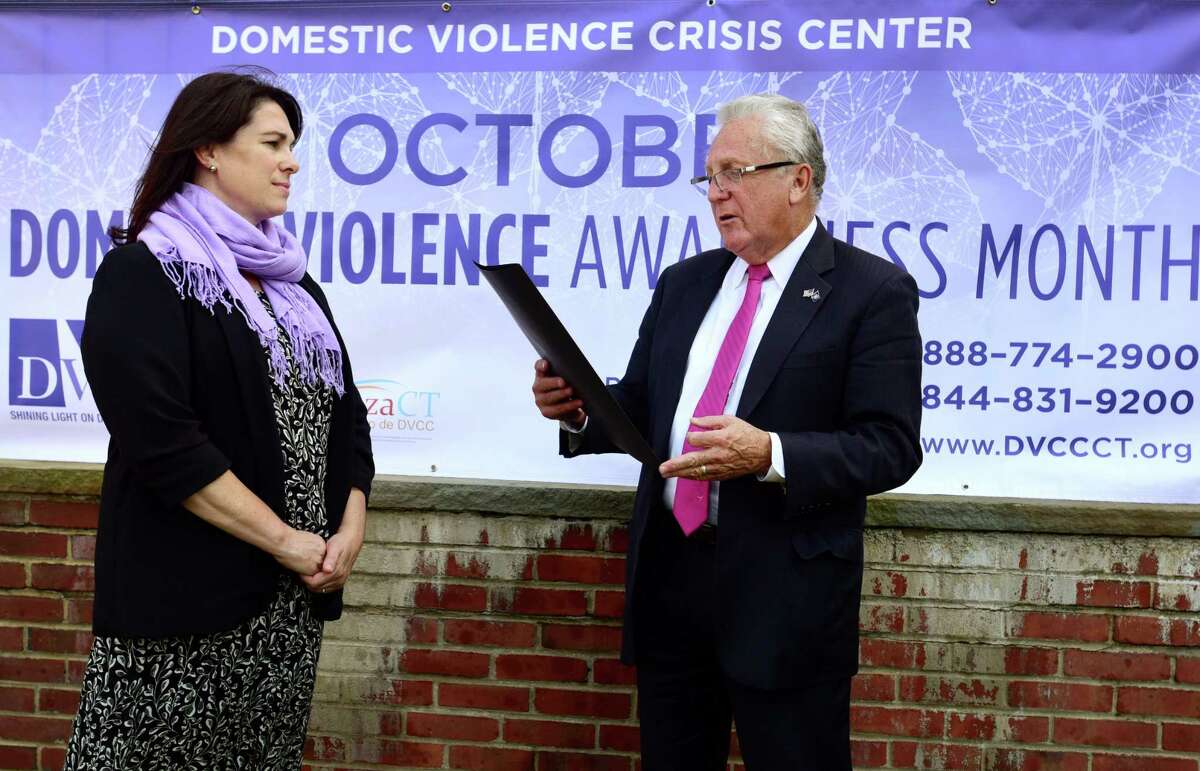 Norwalk Mayor Harry Rilling, right, reads a proclamation to representatives of the Domestic Violence Crisis Center including Executive Director Suzanne Adam, left, and the Norwalk Police Department during a special event Tuesday, October 1, 2019, announcing October as Domestic Violence Awareness Month in front of City Hall in Norwalk, Conn.