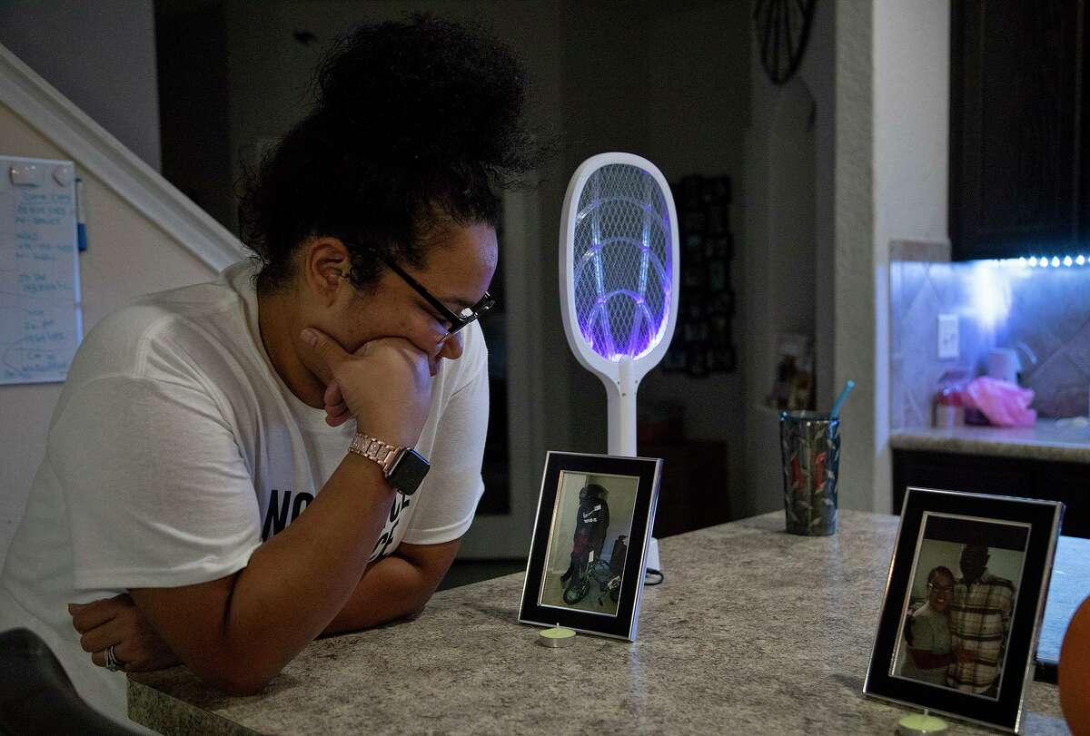 Melissa Zemault Wicker looks at a photograph of her father, Darrell Zemault Sr. at her home in San Antonio on Wednesday, Sept. 23, 2020. Wicker placed photos of her father in several places in her kitchen, dining room and living room in the days since his death.