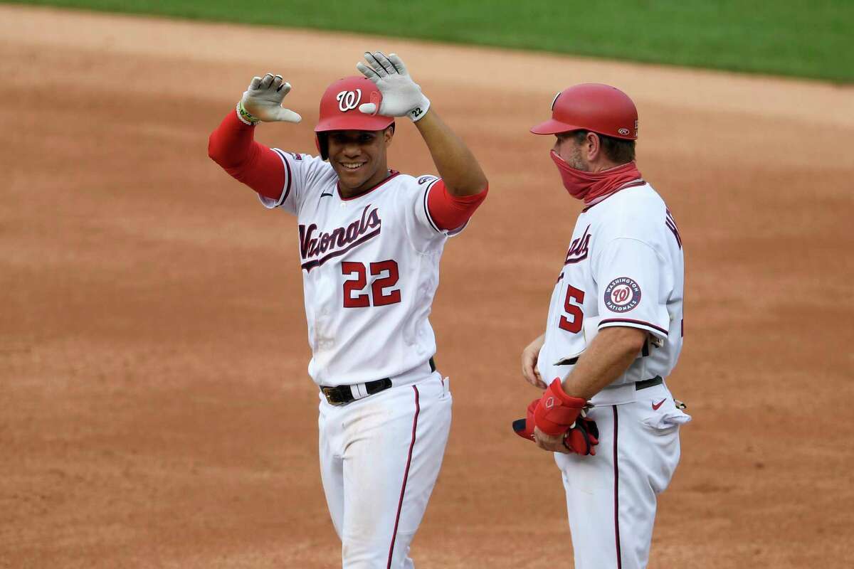 Washington Nationals' Juan Soto (22) reacts at first after his single during the second inning of a baseball game against the New York Mets, Sunday, Sept. 27, 2020, in Washington. Nationals first base coach Bob Henley, right. (AP Photo/Nick Wass)