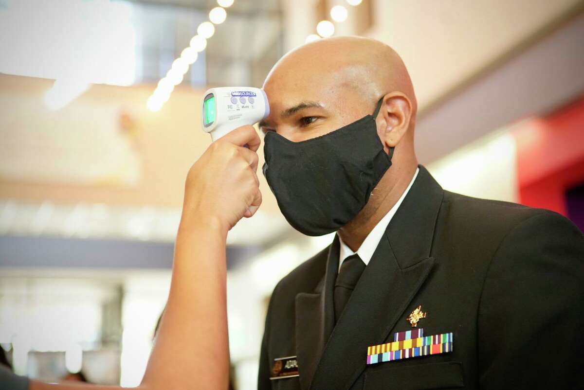 U.S. Surgeon General Jerome Adams has his temperature checked before a meeting with local political and health officials at The Health Museum on Sunday, Sept. 26, 2020, in Houston.