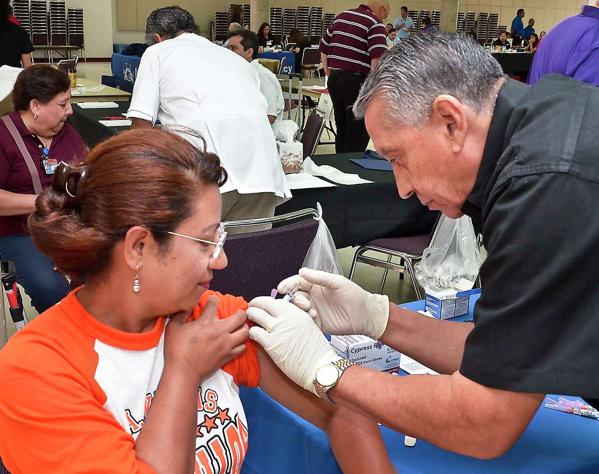 Mabel Cadena, empleada de Kawas Elementary, recibió una vacuna contra la gripe del farmacéutico H-E-B Alvaro Liendo en agosto de 2012, cuando Laredo ISD organizó una feria de salud para sus empleados como parte de la Convocatoria de Regreso a la Escuela del distrito.