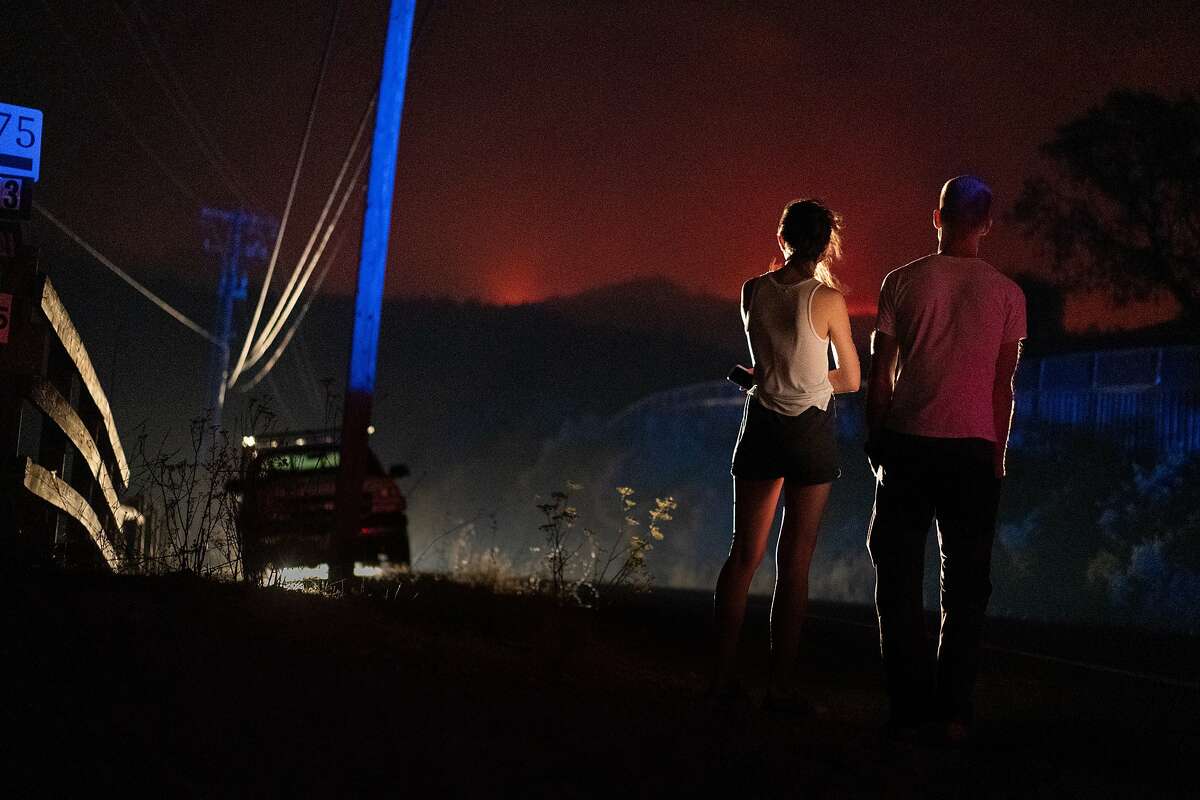A couple watch the Glass fire from Calistoga Road on Sunday, Sept. 27, 2020 in Calistoga, Calif.