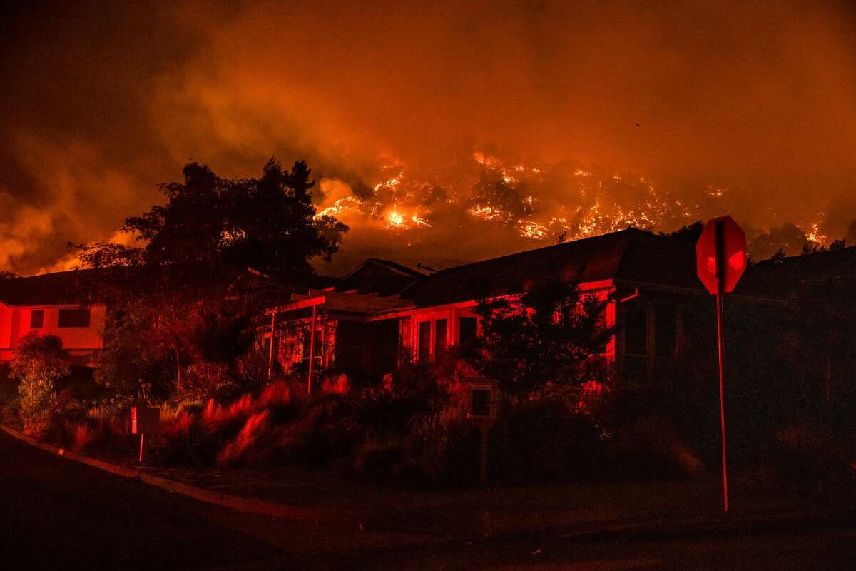 The Shady Fire can be seen on the hillside behind homes in Santa Rosa, on September 28, 2020. - The wildfire quickly spread over the mountains and reached Santa Rosa where it has begun to affect homes.