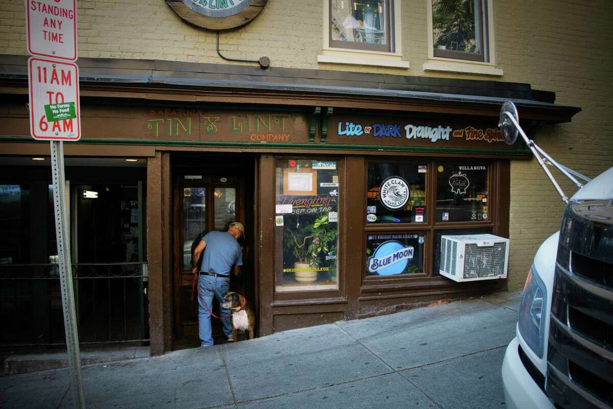 Tin & Lint owner Jim Stanley, with his dog Scarlett, locks up his bar on Wednesday, Sept. 23, 2020, in Saratoga Springs, N.Y. (Paul Buckowski/Times Union)