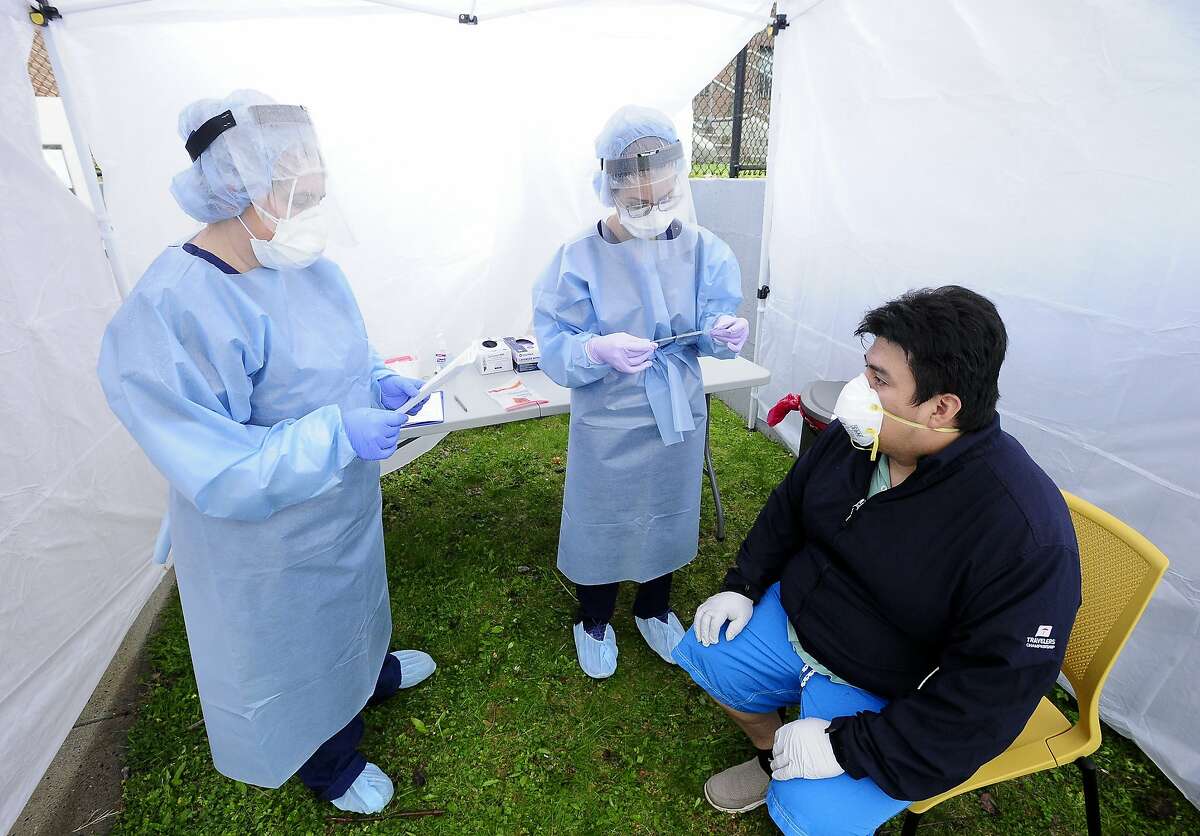 Medical workers prepare to test Greenwich resident Walter Aucay, 36, for COVID-19 at a testing site set up at the Family Center at Wilbur Peck Court in Greenwich, on May 1, 2020.