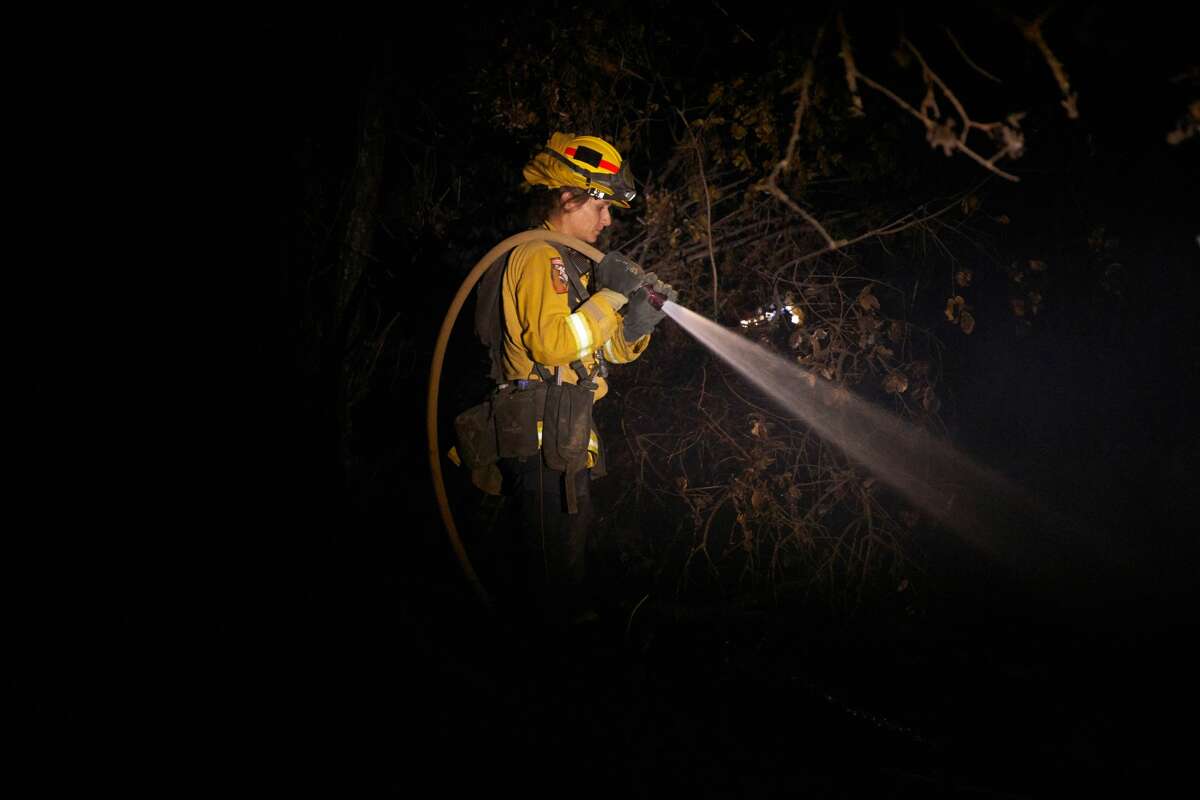 A fire fighter puts out hot spots from the Zogg fire in Igo on September 27, 2020.
