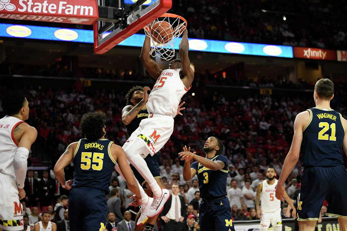 Maryland forward Jalen Smith (25) dunks against Michigan guard Eli Brooks (55), guard Zavier Simpson (3) and forward Isaiah Livers, back, during the second half of an NCAA college basketball game, Sunday, March 8, 2020, in College Park, Md.