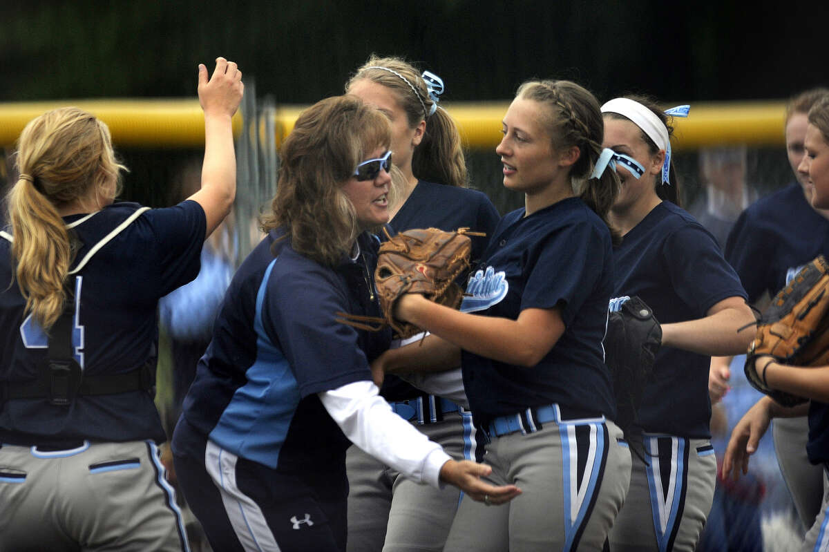 Meridian's Taylor Smith (foreground right) is greeted by her mother, Mustangs' coach Jamie Smith, following an inning-ending double play in a June 11, 2011 postseason game.