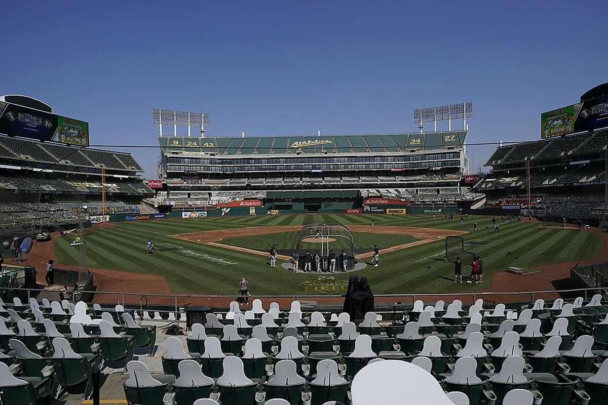 Cutouts fill the stands at the Coliseum as Chicago White Sox players work out in advance of Tuesday’s first game of the Chicago-Oakland wild card series.