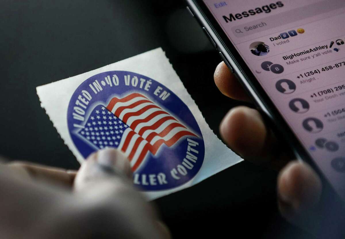 Drew William, a sophomore from Prairie View A&M University, looks at the sticker he received after voting at the Waller County Courthouse during early voting Wednesday, Oct. 24, 2018, in Hempstead. On the ride back to campus, William proudly called his father and texted friends encouraging them to vote.