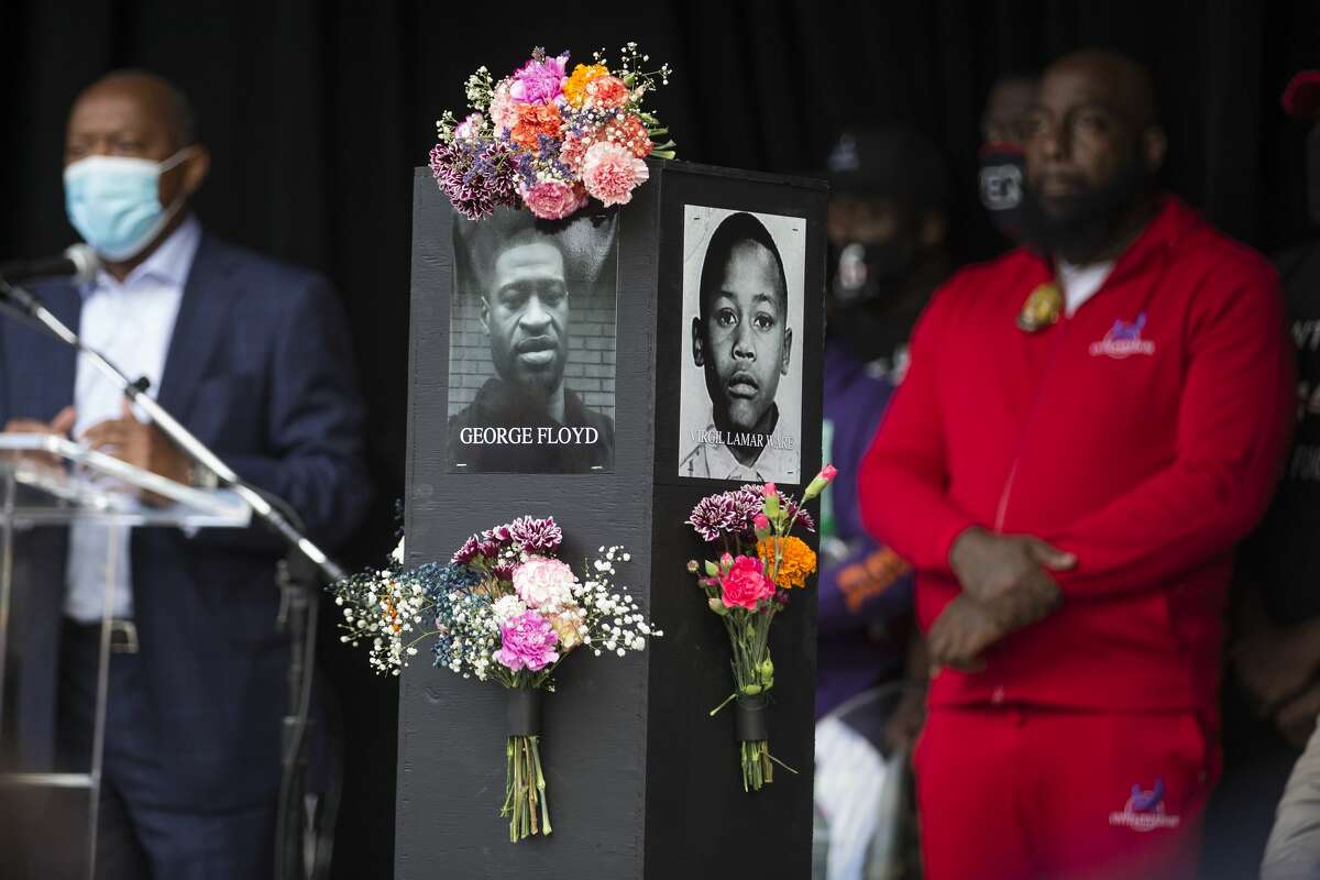 A photo of George Floyd is shown on a pillar as Mayor Sylvester Turner speaks during the opening of the Say Their Names Memorial in Emancipation Park on Monday, Sept. 28, 2020 in Houston. Brought to Houston by rap artist and activist Trae Tha Truth and Say Their Names, the memorial is dedicated to those who have lost their lives due to racial injustice. More than 200 photos, including George Floyd, Breonna Taylor, Dr. Martin Luther King, Jr., and Emmett Till to name a few, are featured in the walk of black pillars with photos on each side. The traveling memorial will be installed at the park for 15 days.