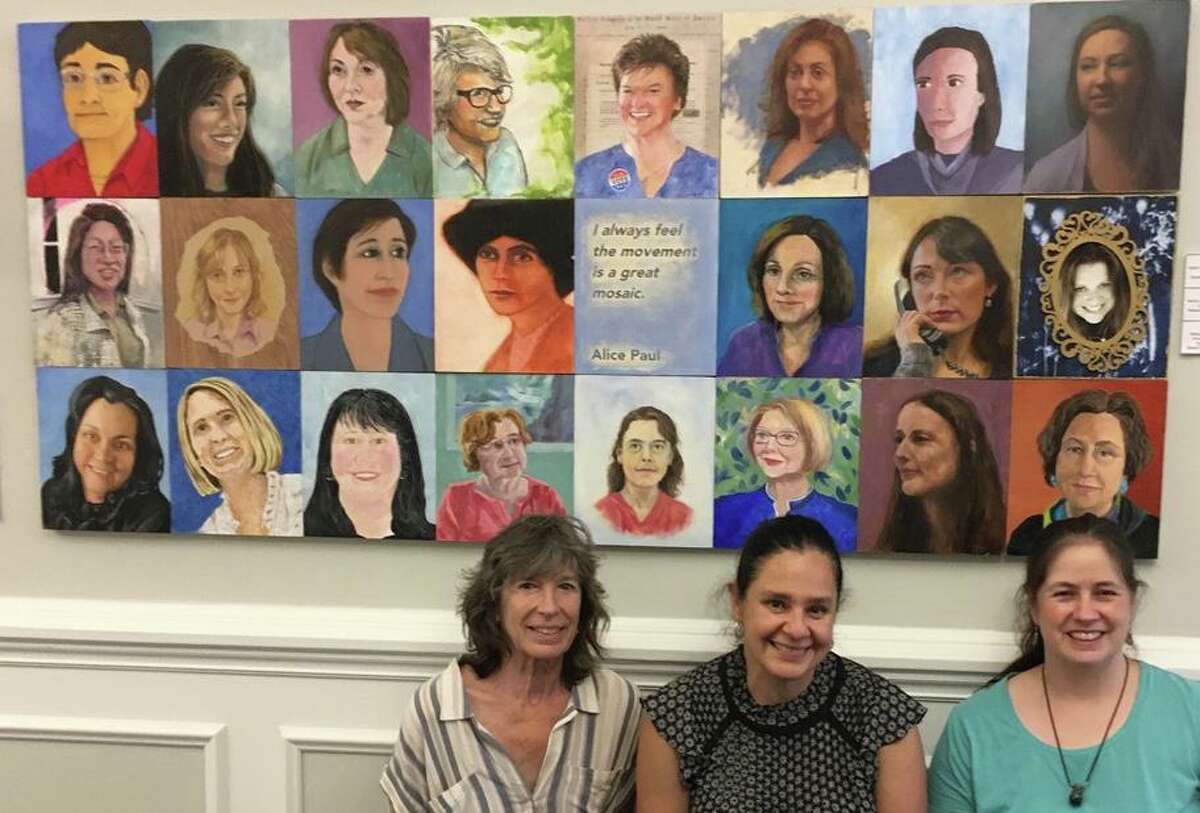 Holly Hawthorn, Lenor Dao and ShawnaLee Kwashnak hung the portraits of town hall women in the front of town hall.