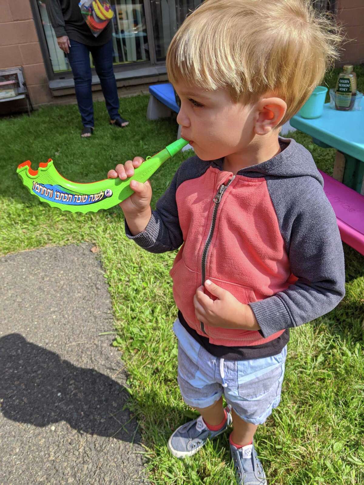 Children at B'nai Torah Nursery School blow shofars (pretend rams' horns) for Rosh Hashanah, the Jewish New Year, which began Friday, Sept. 18 at sundown. Apples and challah are dipped in honey for a sweet new year.