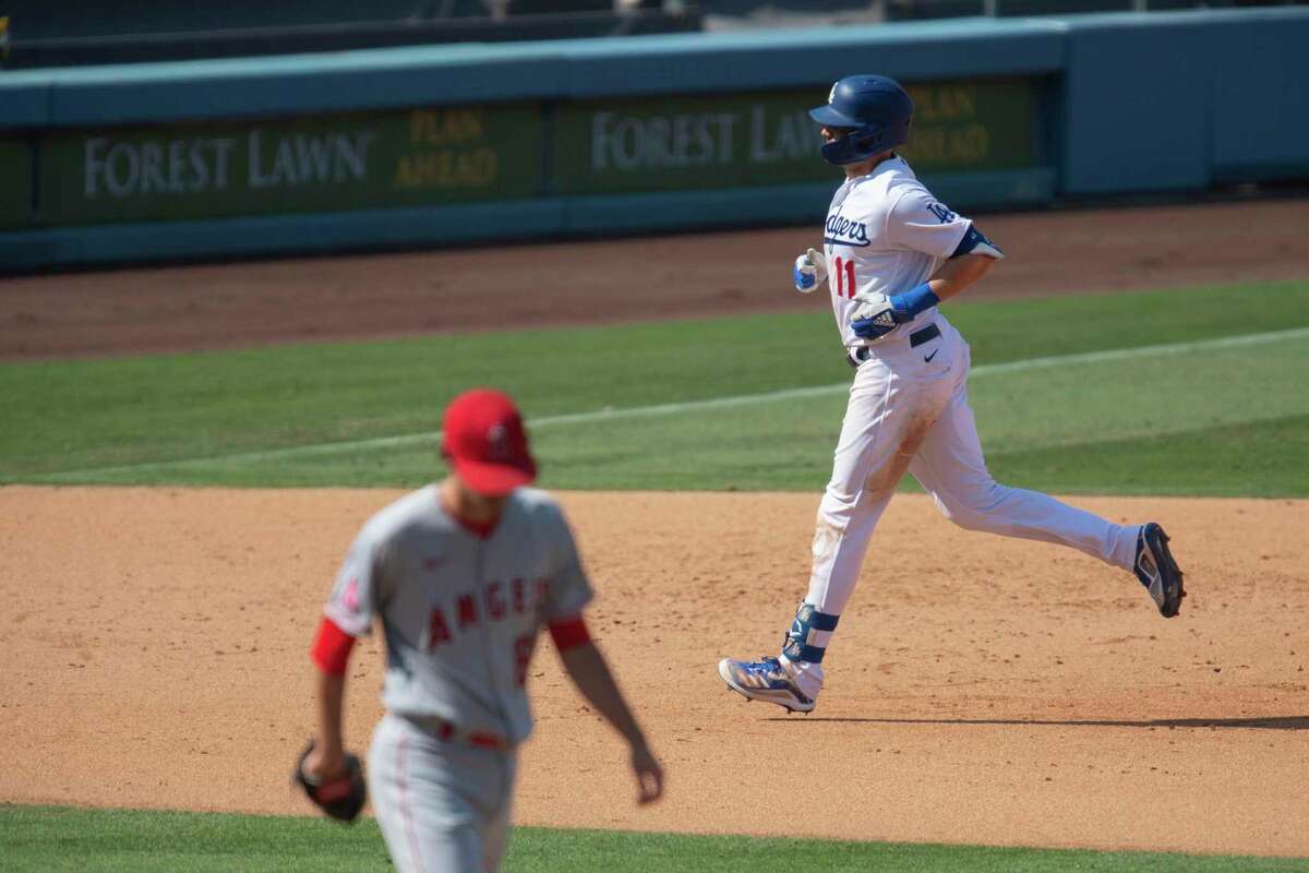 Los Angeles Dodgers' A.J. Pollock, right, rounds the bases after hitting a two-run home run during the seventh inning of a baseball game against the Los Angeles Angels in Los Angeles, Sunday, Sept. 27, 2020. (AP Photo/Kyusung Gong)