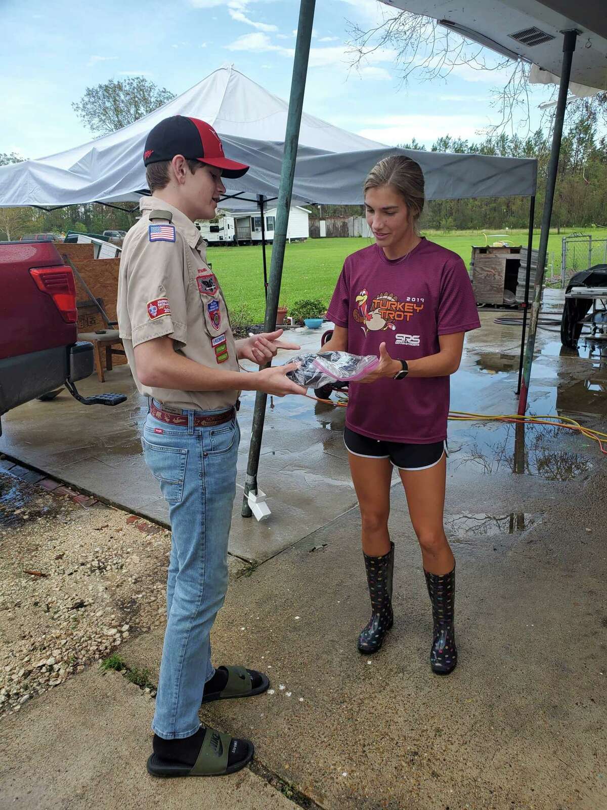After Hurricane Laura swept through East Texas and over the border to Louisiana, local Boy Scout Troop 777 began gathering supplies for the storm's victims in Lake Charles. In a few weeks, they will return to help the victims rebuild. Pictured, Rafe Kotalik explains how to use a solar shower to a resident of the Lake Charles area.