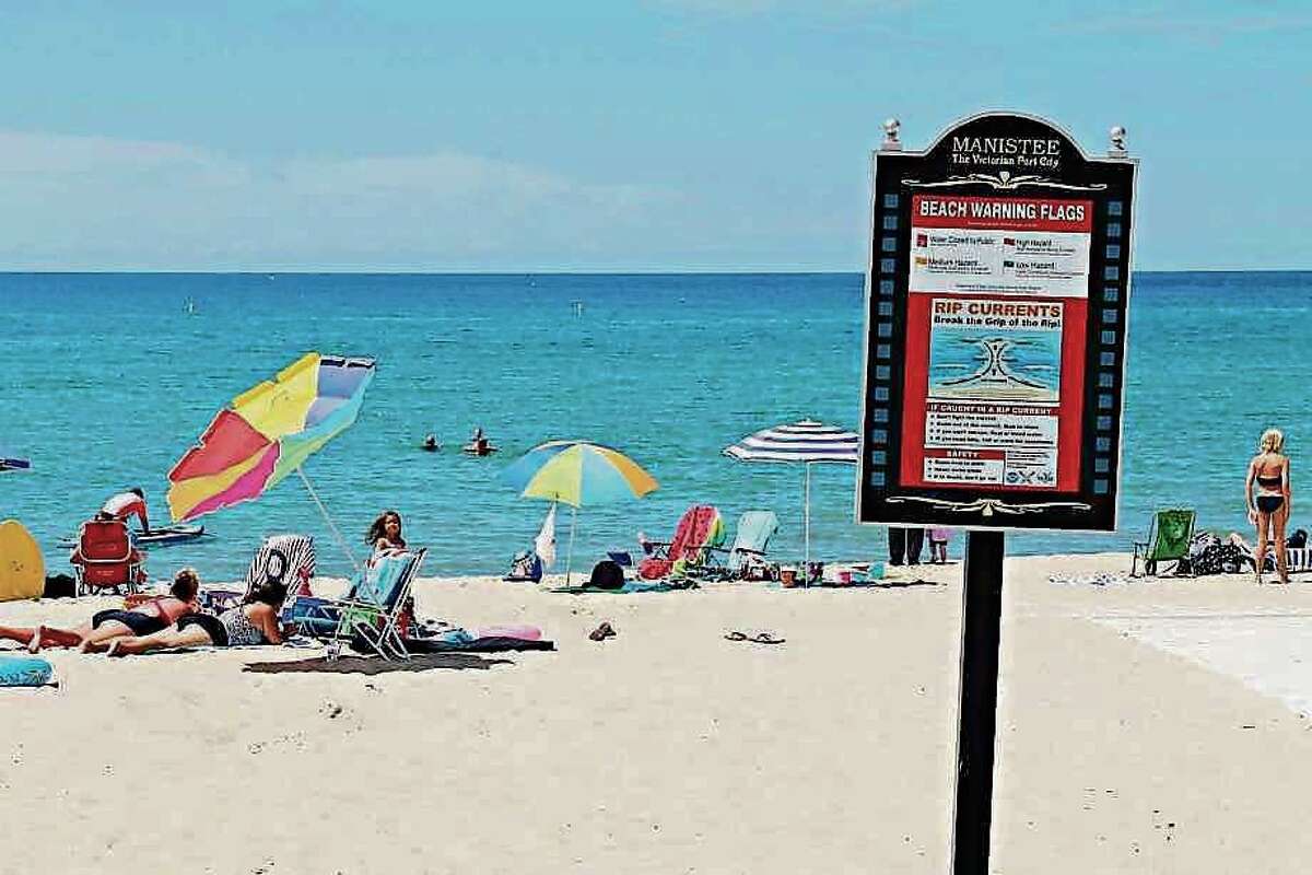 A sign at First Street Beach in Manistee warns of possible rip currents, as well as explaining the meaning of the beach warning flags that can be found at First Street Beach and Fifth Avenue Beach.