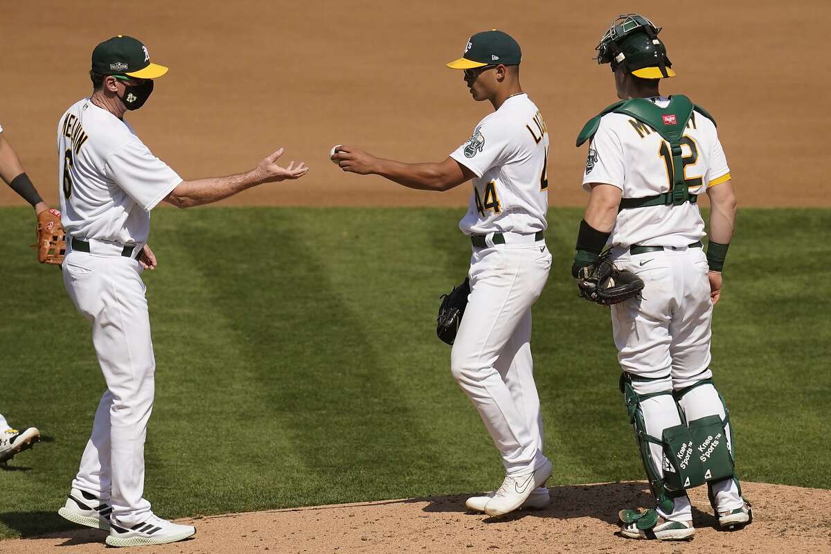Oakland Athletics pitcher Jesus Luzardo, center, hands the ball to manager Bob Melvin as he is relieved during the fourth inning of Game 1 of an American League wild-card baseball series against the Chicago White Sox Tuesday, Sept. 29, 2020, in Oakland, Calif. Also pictured at right is catcher Sean Murphy. (AP Photo/Eric Risberg)