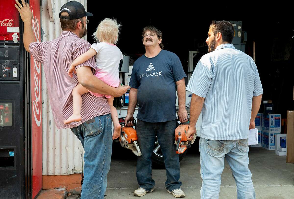 Dennys Myers (center) chats with Jeff Parady (left) and AJ Taege as they work to repair chain saws in the garage of Parady's shop Pope Valley Repair and Towing in order to assist fighting any coming fire in Pope Valley, Calif. Tuesday, September 29, 2020. Evacuation warnings were upgraded to orders in the Angwin and Pope Valley areas as the Glass Fire moved south. The Glass Fire has burned more than 42,000 acres by Tuesday morning and is 0% contained.