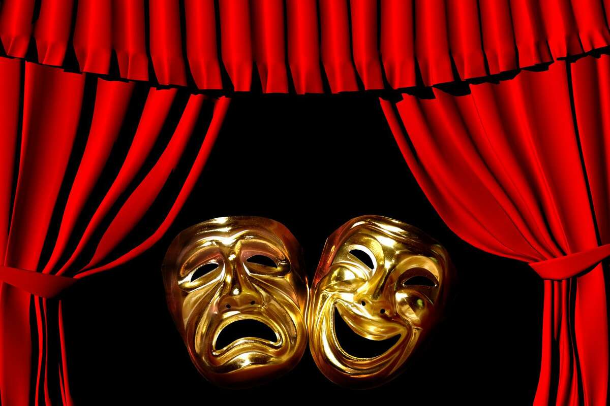 Gold mask of tragedy and comedy between a red theatre curtain