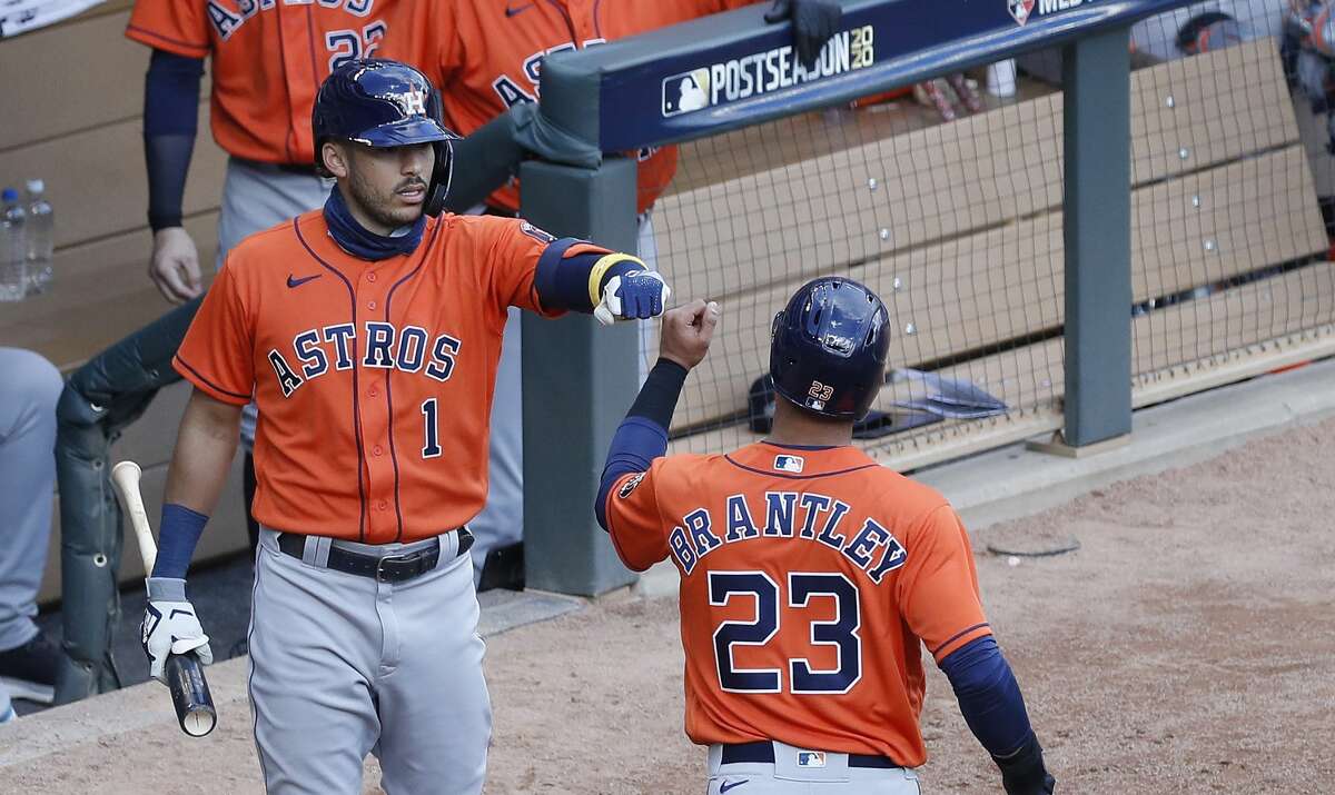 Houston Astros Michael Brantley (23) celebrates with Carlos Correa (1) after he scored a run on Kyle Tucker's RBI single during the fourth inning of Game 2 of an MLB Wild Card game at Target Field, Wednesday, September 30, 2020, in Minneapolis.