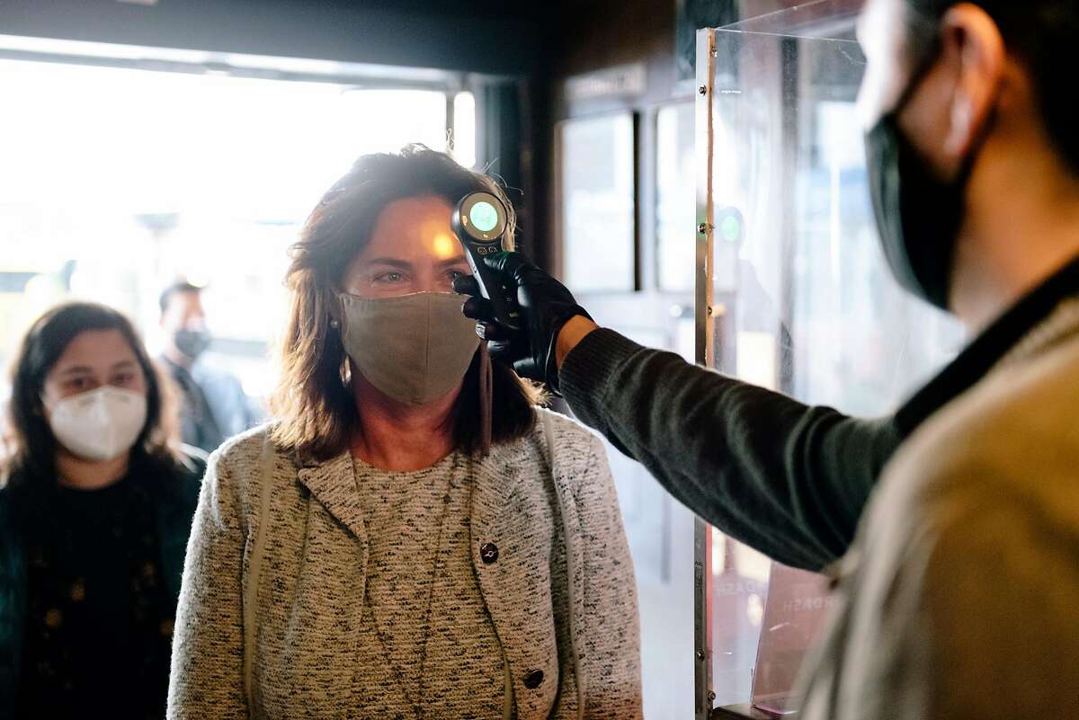 Guest Karin Flood has her temperature taken by manager Christian Renteria upon entering at John's Grill in San Francisco, Calif, on Wednesday, September 30, 2020. San Francisco moved to allow restaurants to offer indoor dining again for guests at a limit of twenty five percent capacity.