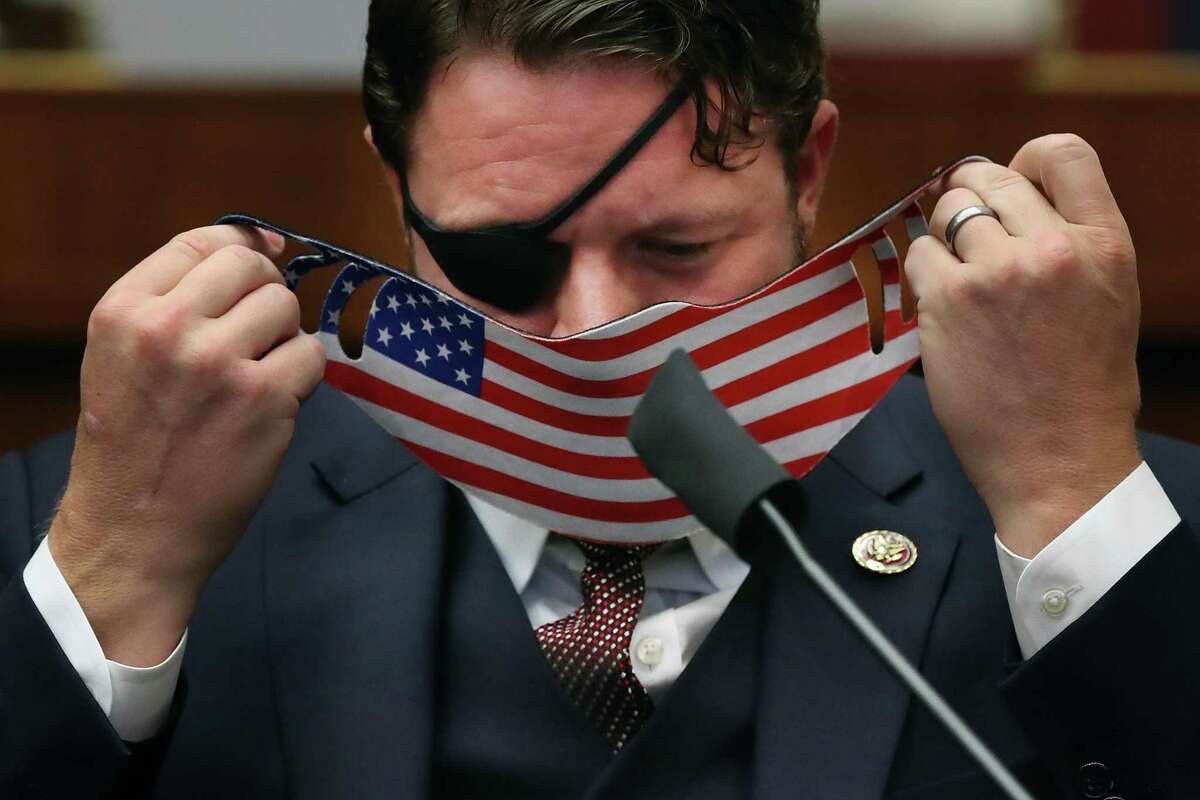 House Homeland Security Committee member Rep. Dan Crenshaw (R-TX) replaces his face mask during a hearing on 'worldwide threats to the homeland' in the Rayburn House Office Building on Capitol Hill September 17, 2020 in Washington, DC.