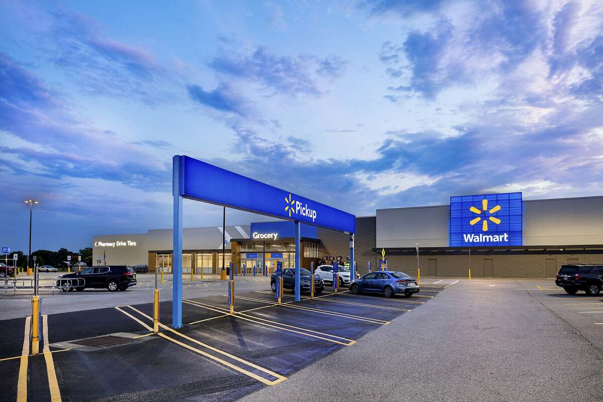 This July 2020 photo provided by Walmart shows the bright signage and Walmart logos from the parking lot outside the Walmart Supercenter in Springdale, Ark. Walmart is getting inspiration from the airport terminal as it revamps the layout and signage of its stores to speed up shopping and better cater to smartphone-armed customers. (Mark Steele + FITCH/Courtesy of Walmart via AP)