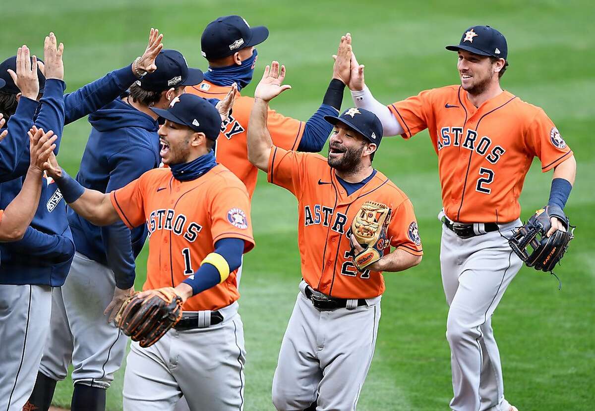 Astros infielders Carlos Correa (left), Jose Altuve and Alex Bregman greet teammates after they eliminated the Minnesota Twins with a 3-1 win in the second game of their wild-card series at Target Field in Minneapolis.