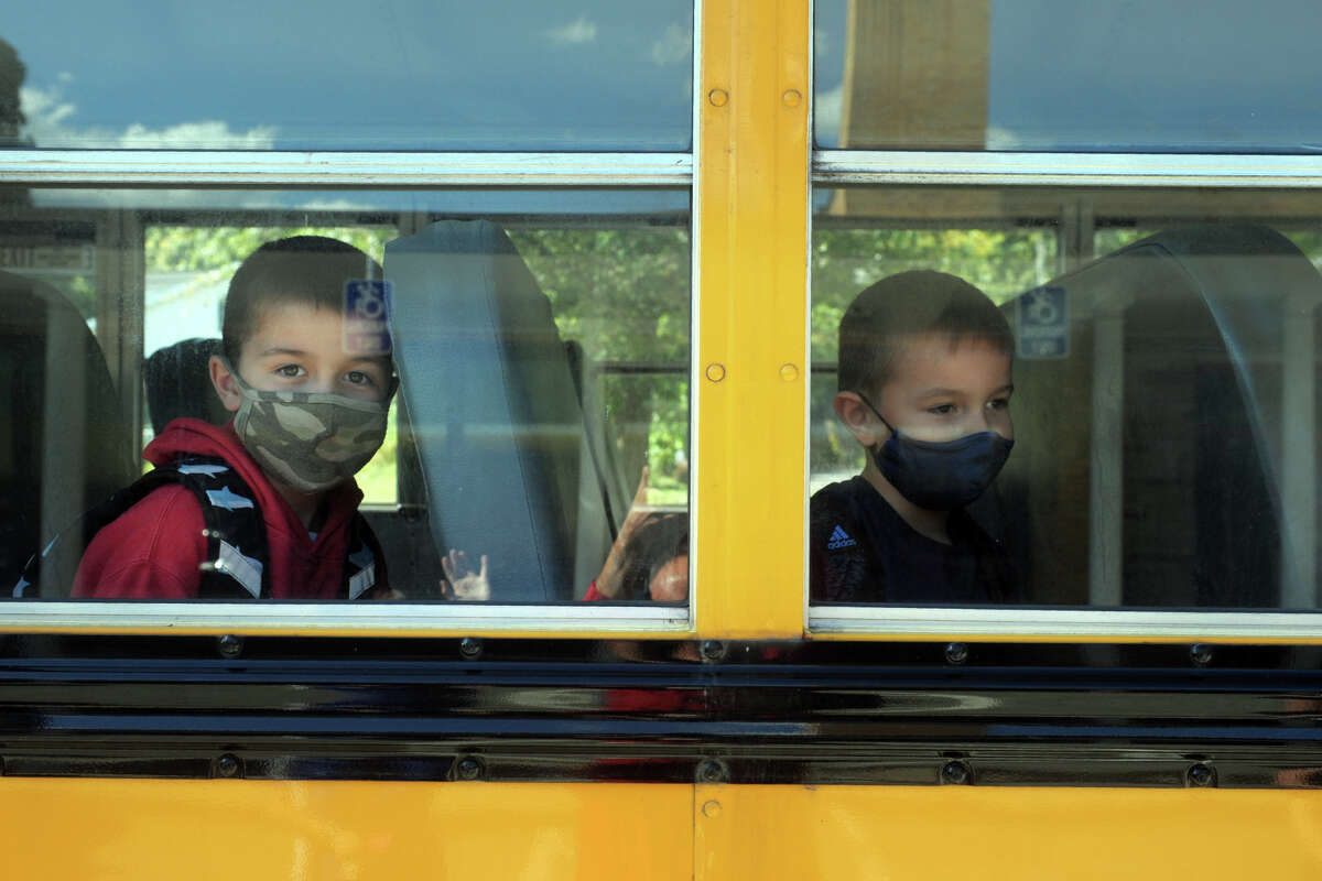 Second graders Logan Vanhoose, left, and Fabian Stawiarski sit on their bus at the end of the school day at Sunnyside Elementary School, in Shelton, Conn. Sept. 30, 2020.