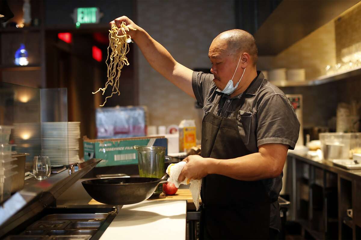 Chef Rob Lam prepares a dish with garlic noodles at Lily in San Francisco. Lily is opening on Oct. 1.