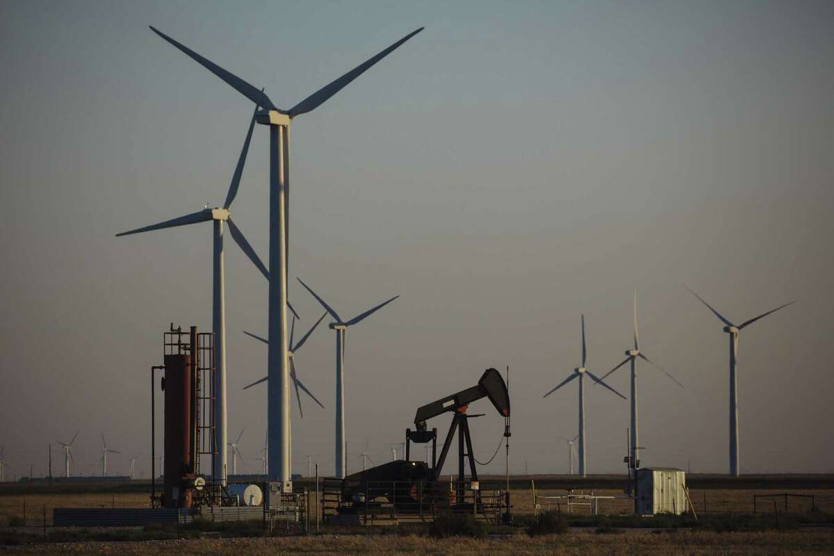 A pump jack stands next to wind turbines near Guymon, Oklahoma, U.S., on Friday, Sept. 25, 2020. After all the trauma the U.S. oil industry has been through this year -- from production cuts to mass layoffs and a string of bankruptcies -- many producers say they’re still prioritizing output over reducing debt. Photographer: Angus Mordant/Bloomberg