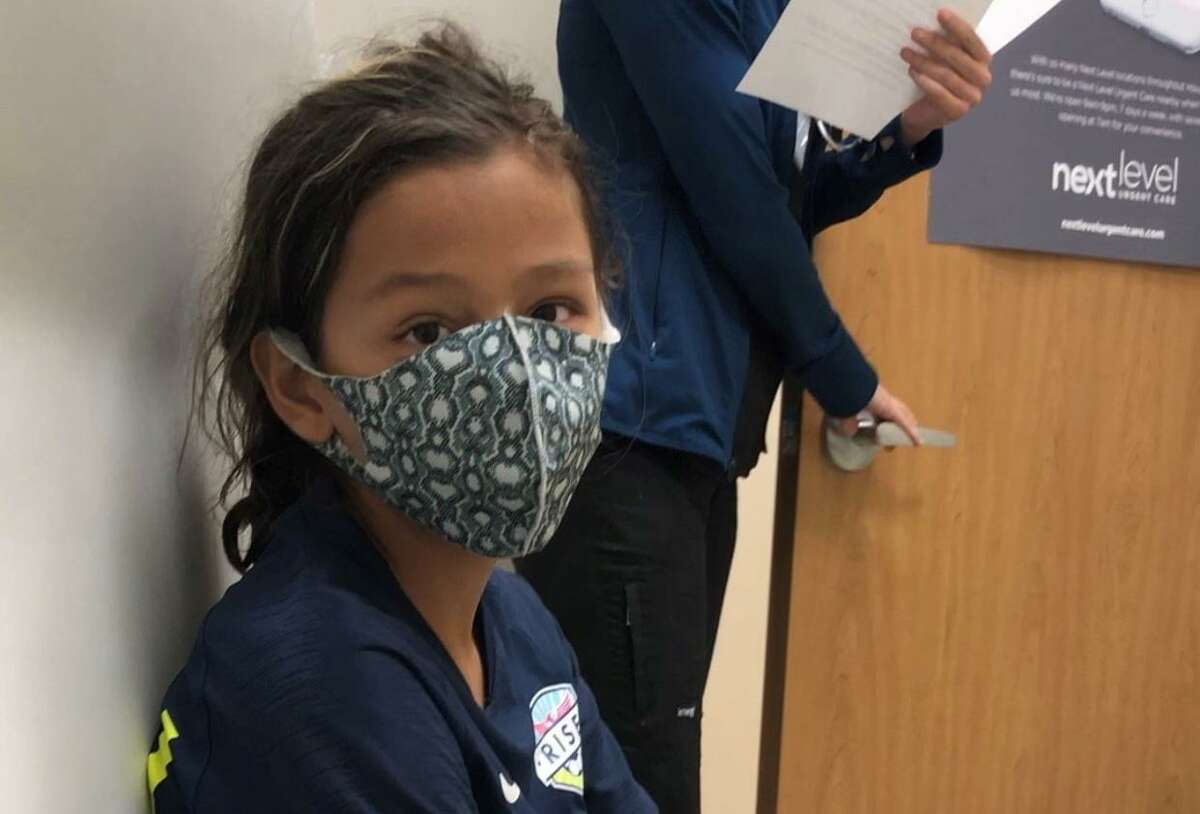 Still in his soccer uniform and cleats at a Southwest Houston clinic on a recent Sunday, Dane Schiller’s son seconds after he heard the results of his coronavirus test.