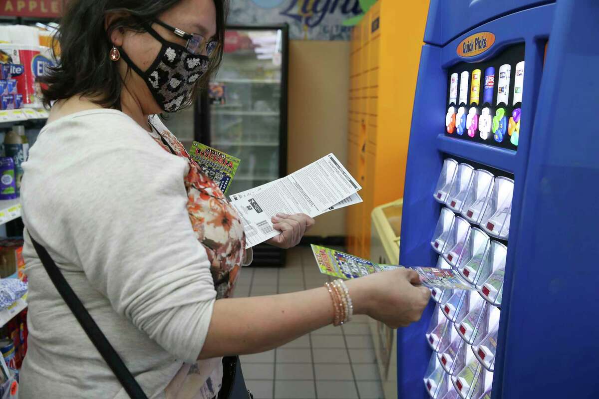 Maribel Fuentes checks her scratch-off tickets in one two kiosks at the Potranco Food Mart on city far northwest side, Thursday, Oct. 1, 2020. The state agency reported $6.704 billion in sales for its 2020 fiscal year ?‘ Oct. 1, 2019, to Sept. 30 ?‘ a 7.5 percent increase over the previous year. The store is the number one seller of tickets in the city.