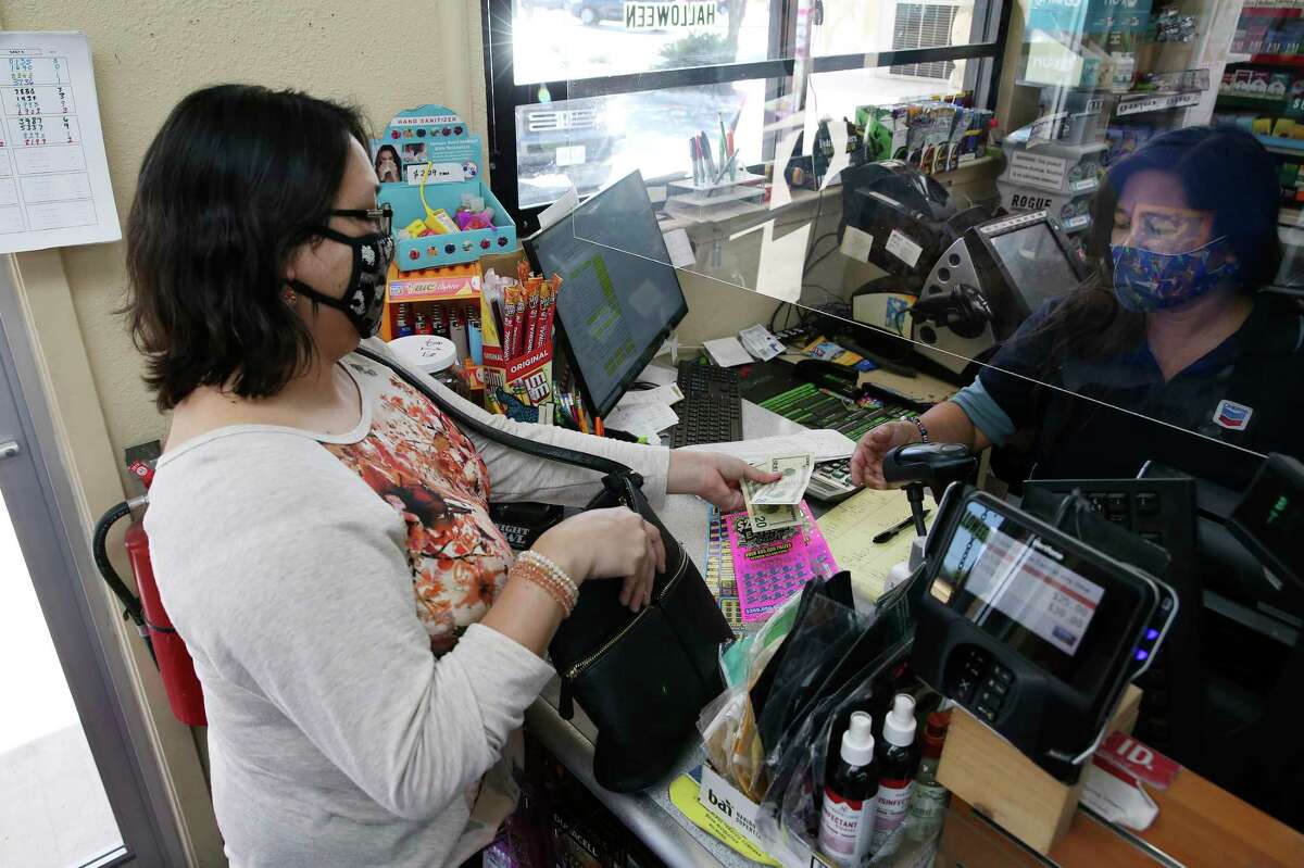Maribel Fuentes buys scratch-off tickets from Mary Bosea at the Potranco Food Mart on city far northwest side, Thursday, Oct. 1, 2020. The state agency reported $6.704 billion in sales for its 2020 fiscal year ?‘ Oct. 1, 2019, to Sept. 30 ?‘ a 7.5 percent increase over the previous year. The store is the number one seller of tickets in the city.