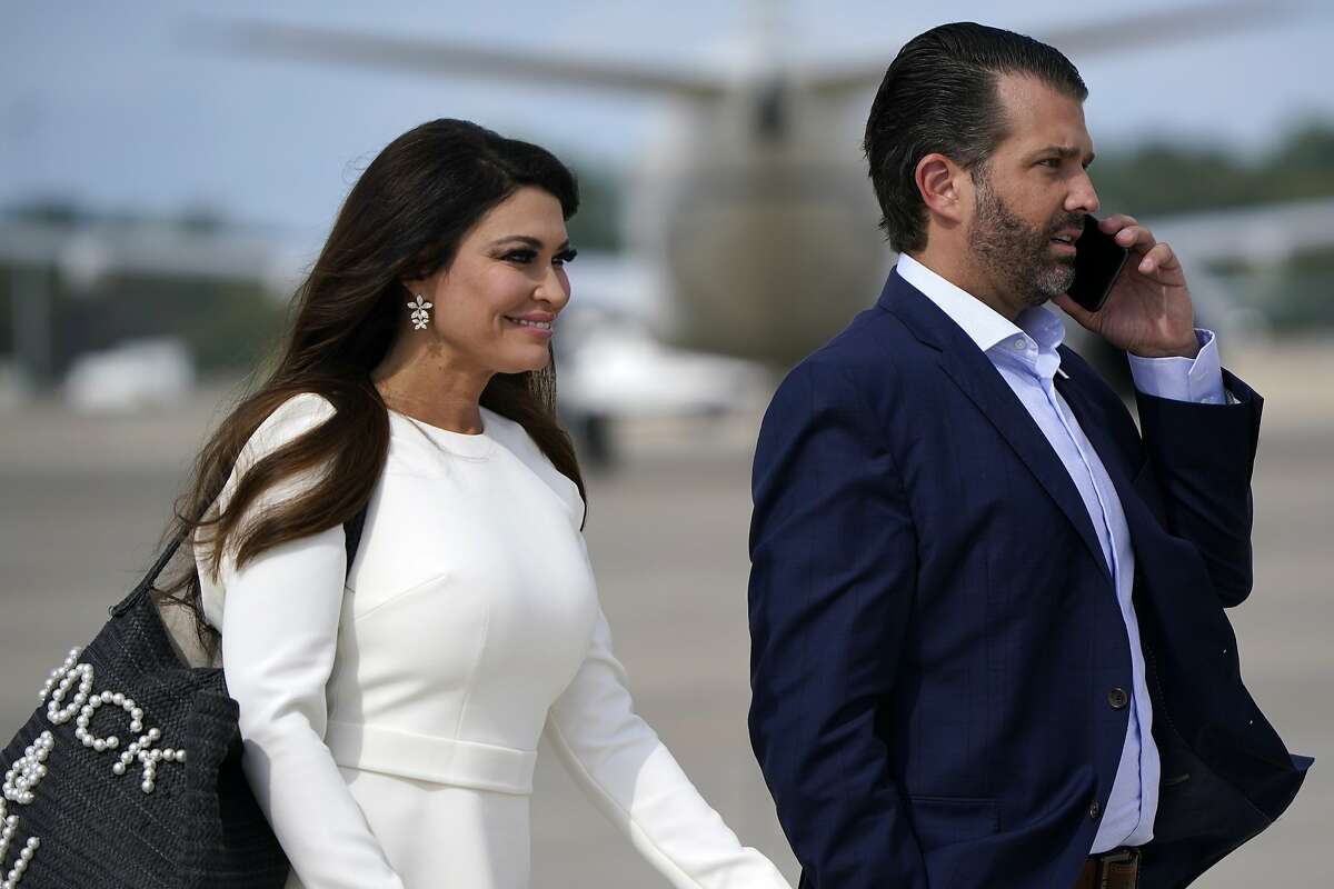 FILE - Donald Trump Jr. and Kimberly Guilfoyle walk across the tarmac to board Air Force One at Andrews Air Force Base before flying to Cleveland, Ohio, for the first presidential debate Tuesday, Sept. 29, 2020.