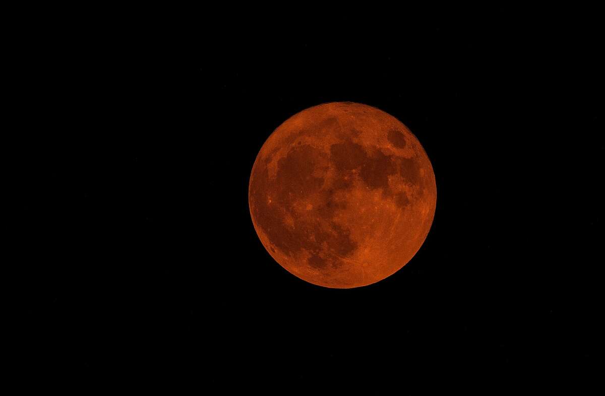 The Harvest Moon for 2020, tinted orange by smoke from the wildfires near the Bay Area, is seen in the sky from Oakland, Calif., on Thursday, October 1, 2020.