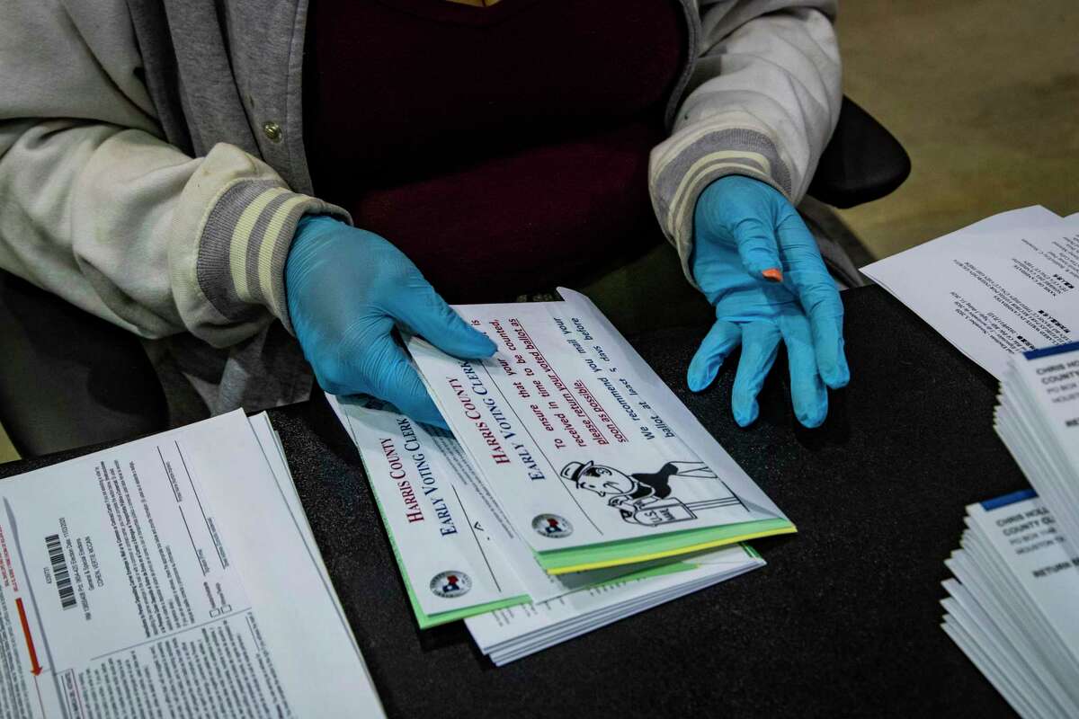 Harris County voting clerk Crystal Lillie, 35, combines the different paperwork that goes inside a ballot envelope in preparation for early voting, Friday, Sept. 25, 2020, in Houston.