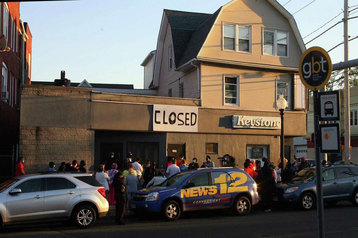 Some 60 people gather to protest in front of the now-shuttered Keystone social club on Barnum Avenue in Bridgeport, Conn., on Thursday Oct. 1, 2020. They demanded the FBI take over the investigation and look into the actions of Bridgeport City Council Member Eneida Martinez, who managed the club.