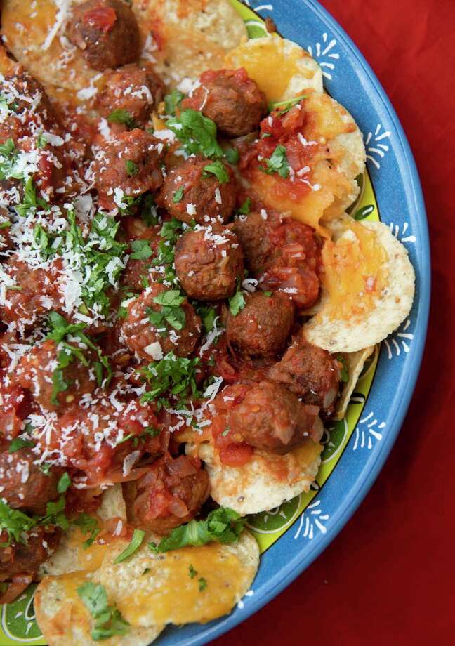 Nachos with meatballs features two crowd-pleasers packed as one hearty snack. Pork meatballs are dunked into a chunky salsa and served on cheesy tortilla chips. (Emily Matthews/TNS) / Pittsburgh Post-Gazette