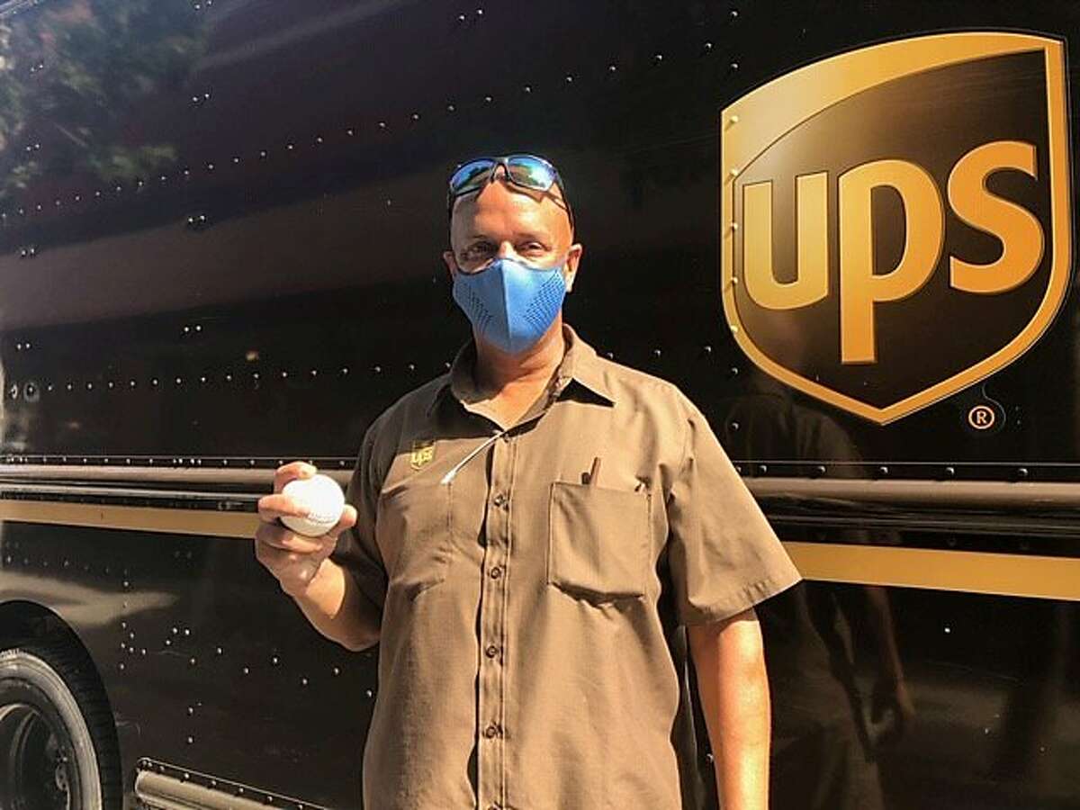 UPS employee Derek Reynolds received a baseball from AP reporter Janie McCauley.