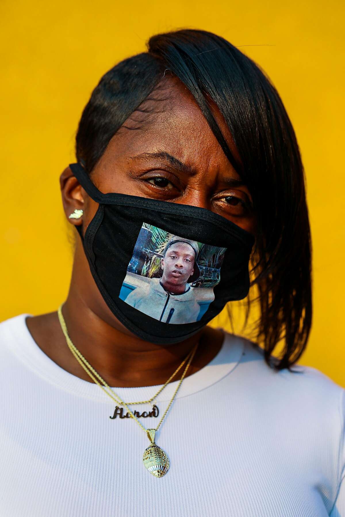 Tiffany Winters wears a mask bearing her slain son’s image.