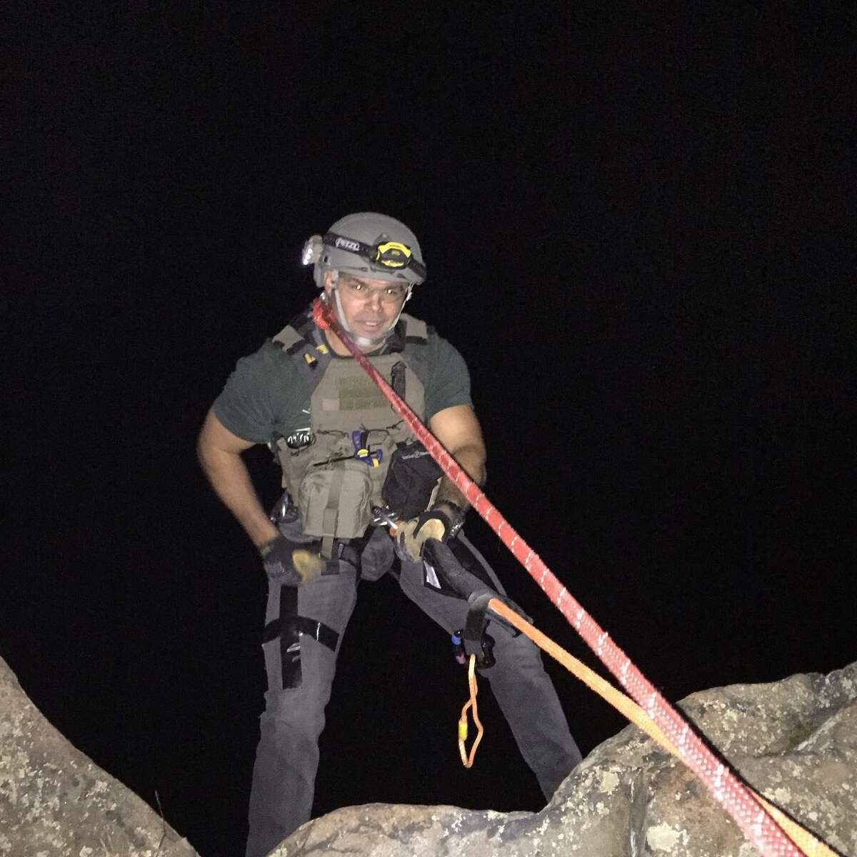 A member of the State Police Bomb Squad rappels 40 feet down a cliff at Sleeping Giant State Park in Hamden Saturday, Oct. 3, 2020, to investigate an item suspected to be a bomb. It was actually an item left to be found be people geocaching in the park.