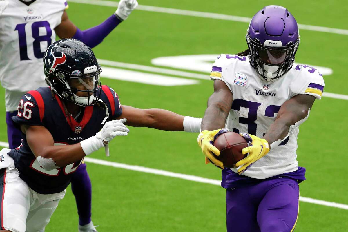 Minnesota Vikings running back Dalvin Cook (33) stretches the ball across the goal line as he runs past Houston Texans cornerback Vernon Hargreaves III (26) for a 7-yard touchdown run during the first half of an NFL football game at NRG Stadium on Sunday, Oct. 4, 2020, in Houston.